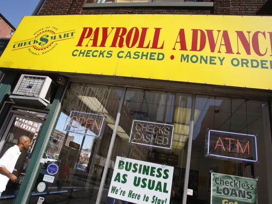 Checksmart storefront. A large banner above the windows and door reads "Payroll Advances, checks cashed, money orders"